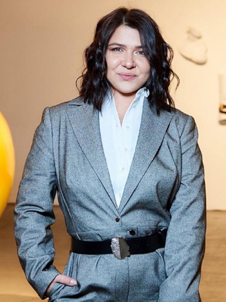 Anastasiia Bratkova in a grey suit at a gallery