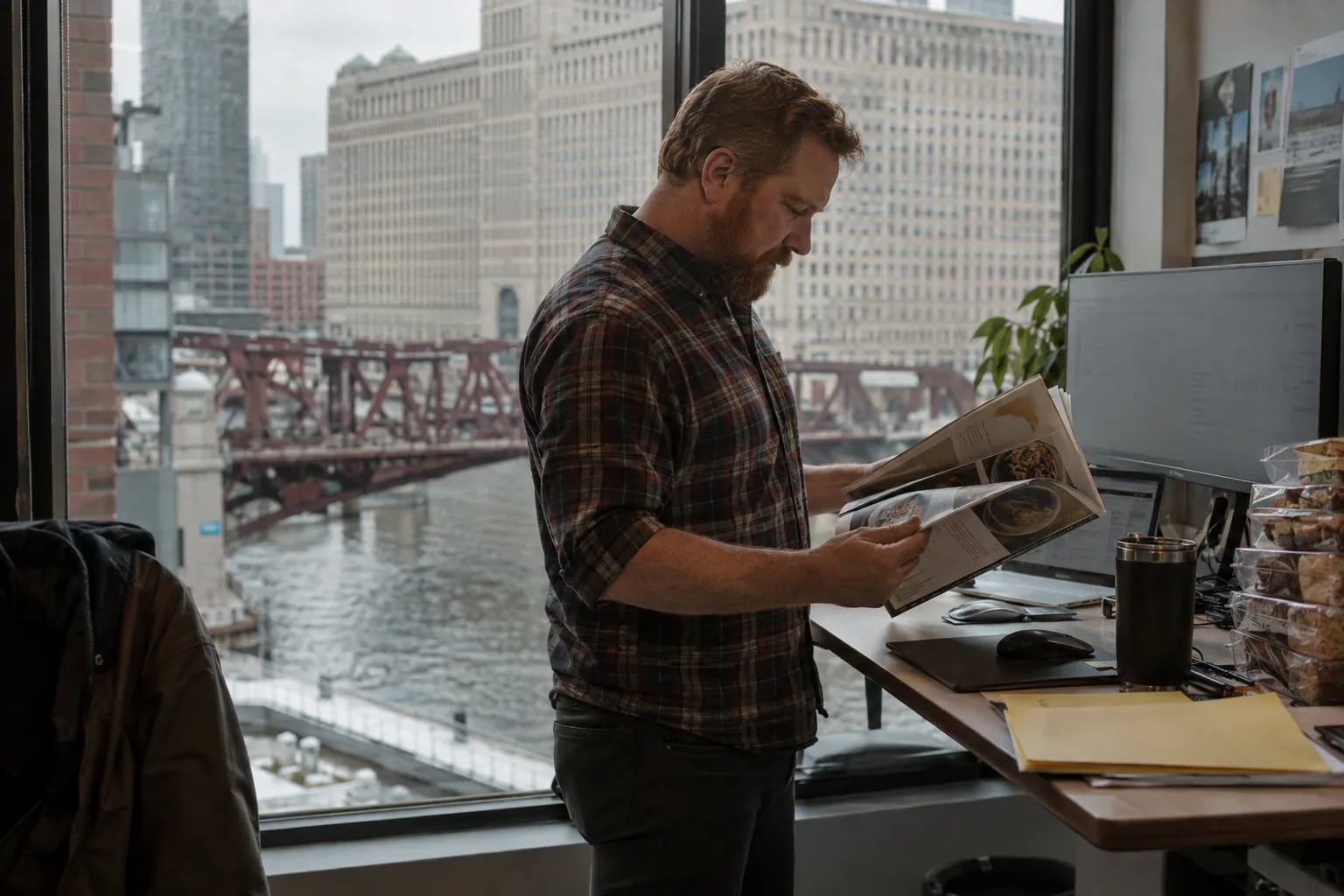 Marketing lead reading a trade magazine by a window over the Chicago River