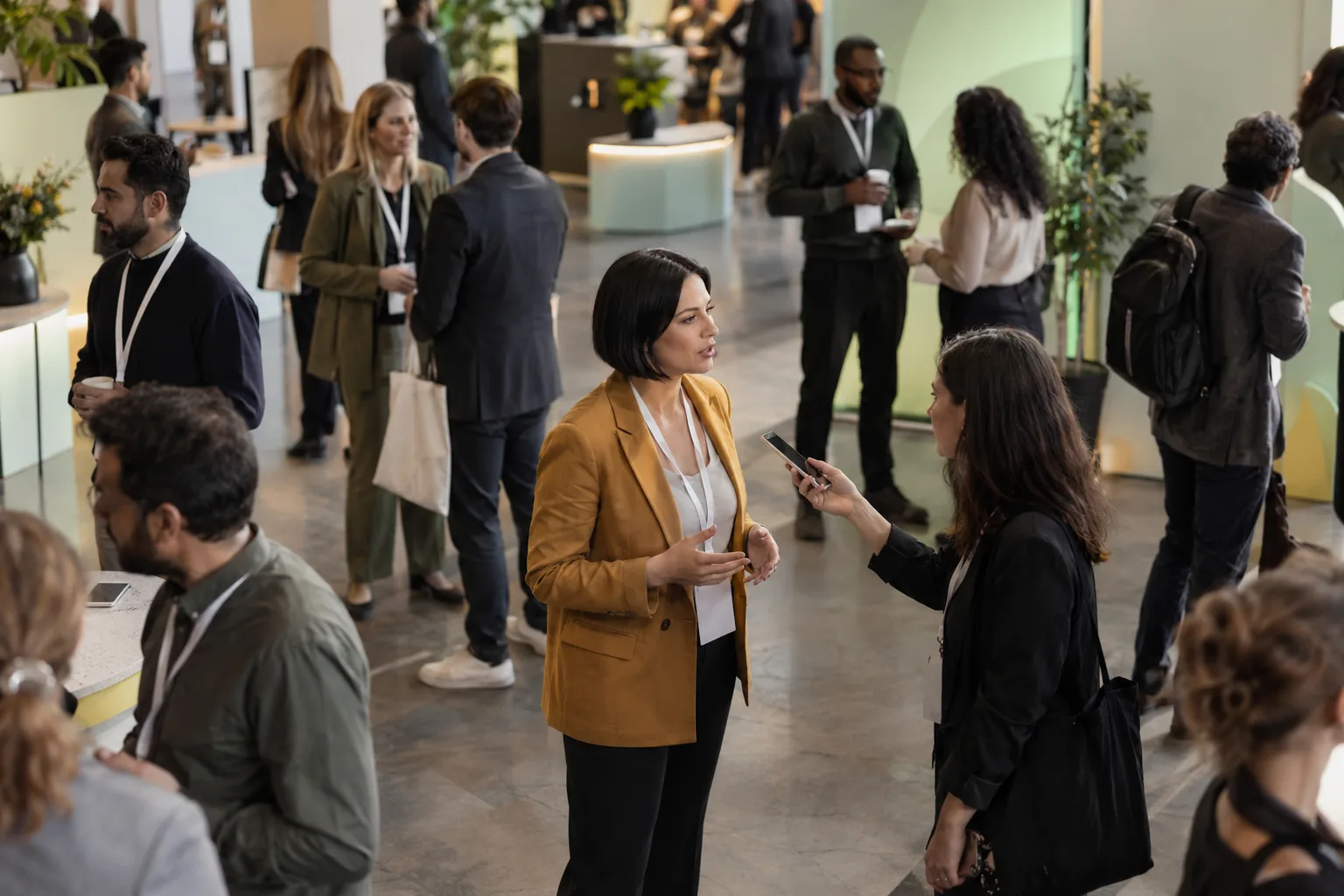 A founder talking to a reporter in a conference hallway